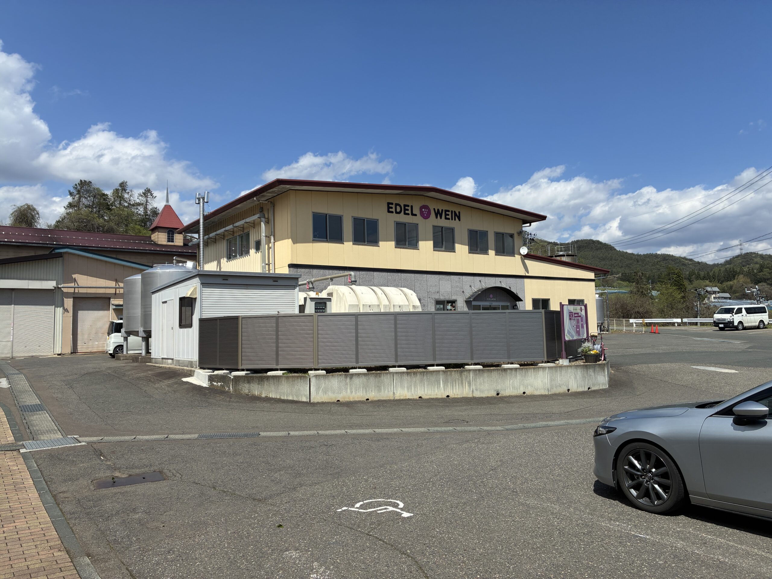 エーデルワインのワイナリー外観。山々を背景に建物が建っている