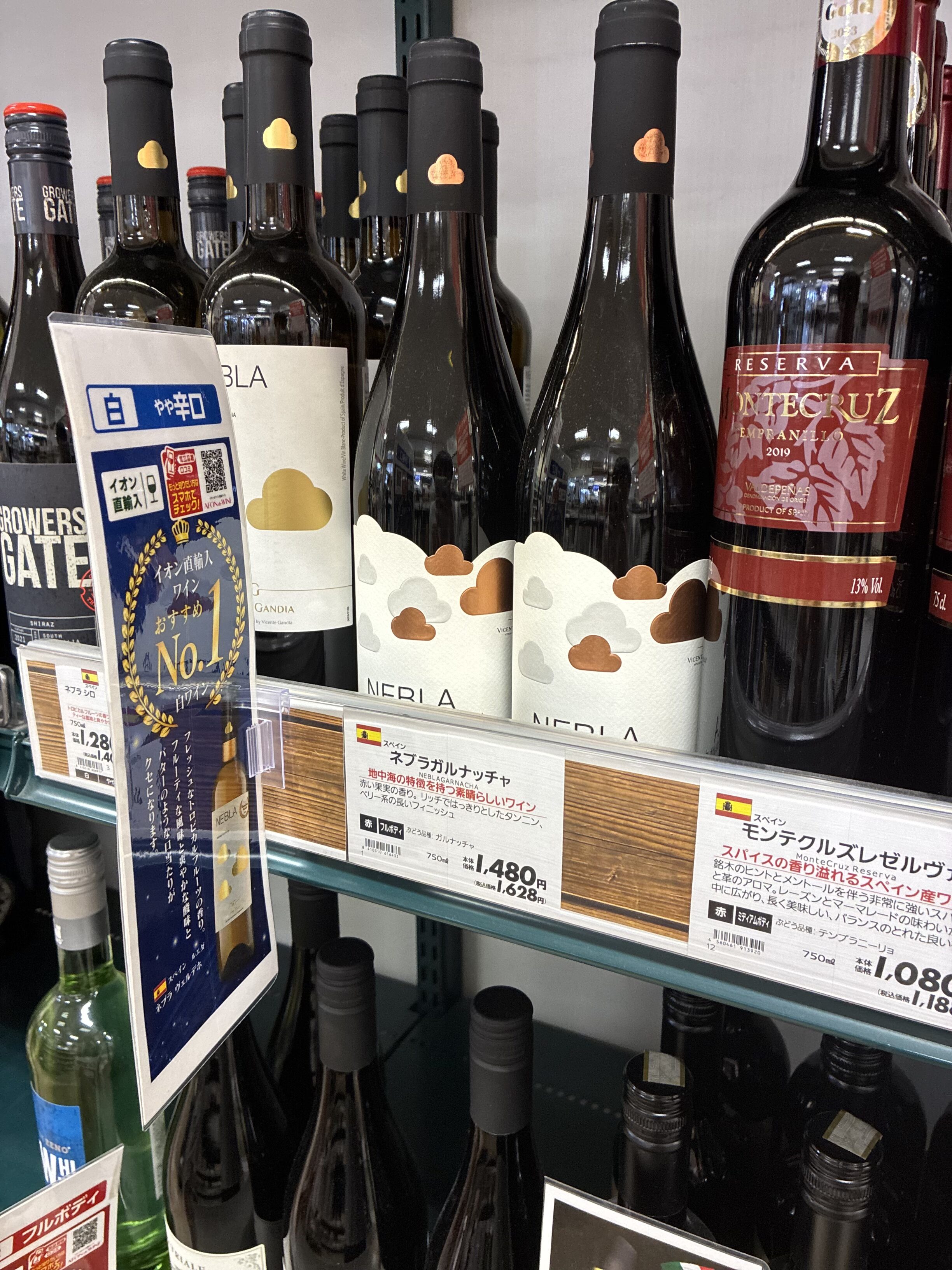 イオンのスペインワイン棚。「イオン直購入 おすすめNo.1白ワイン」ポップのネブラ・ガルナッチャが並ぶ様子。